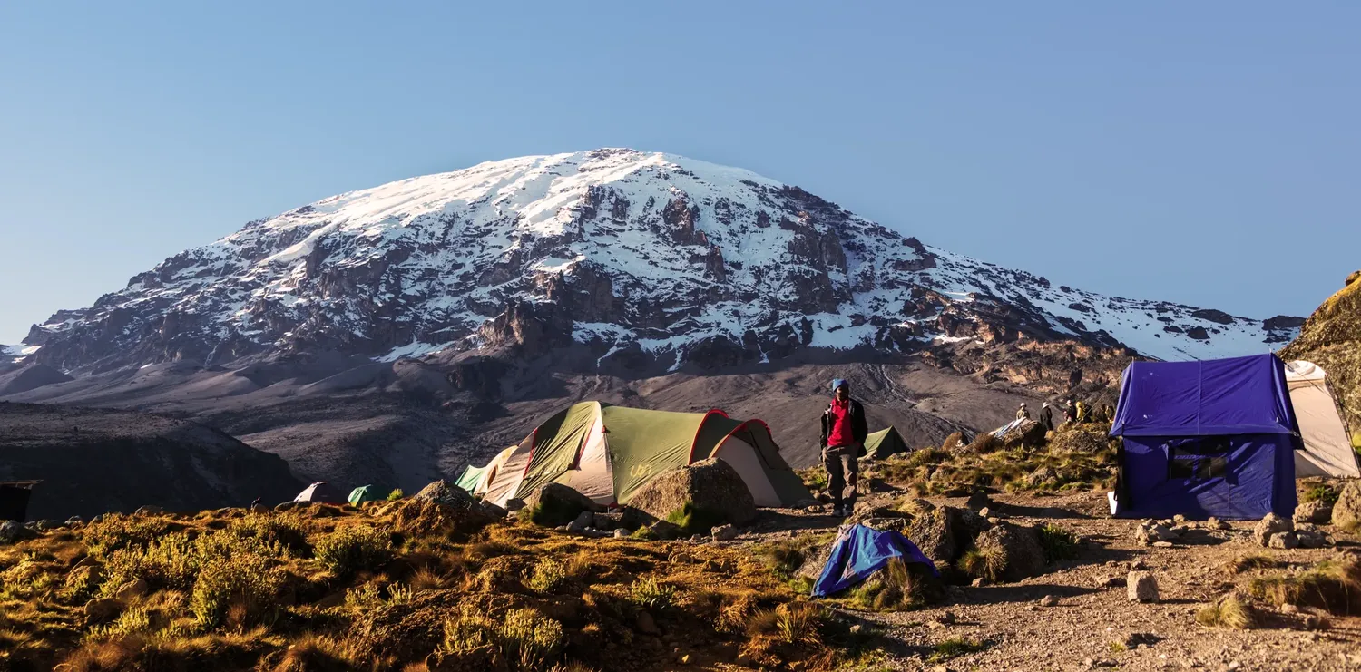 Climbers comparing five-day and six-day Marangu Route itineraries on Mount Kilimanjaro