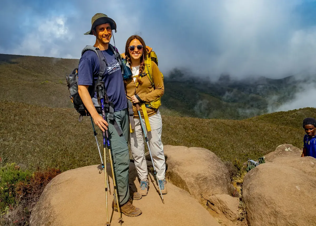A honeymoon couple on a boulder above the clouds on Kilimanjaro