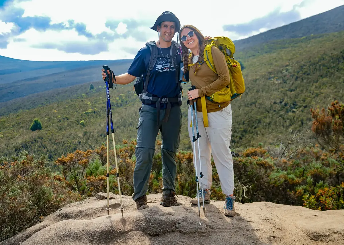 A honeymoon couple on a rock above the heath on the Lemosho route