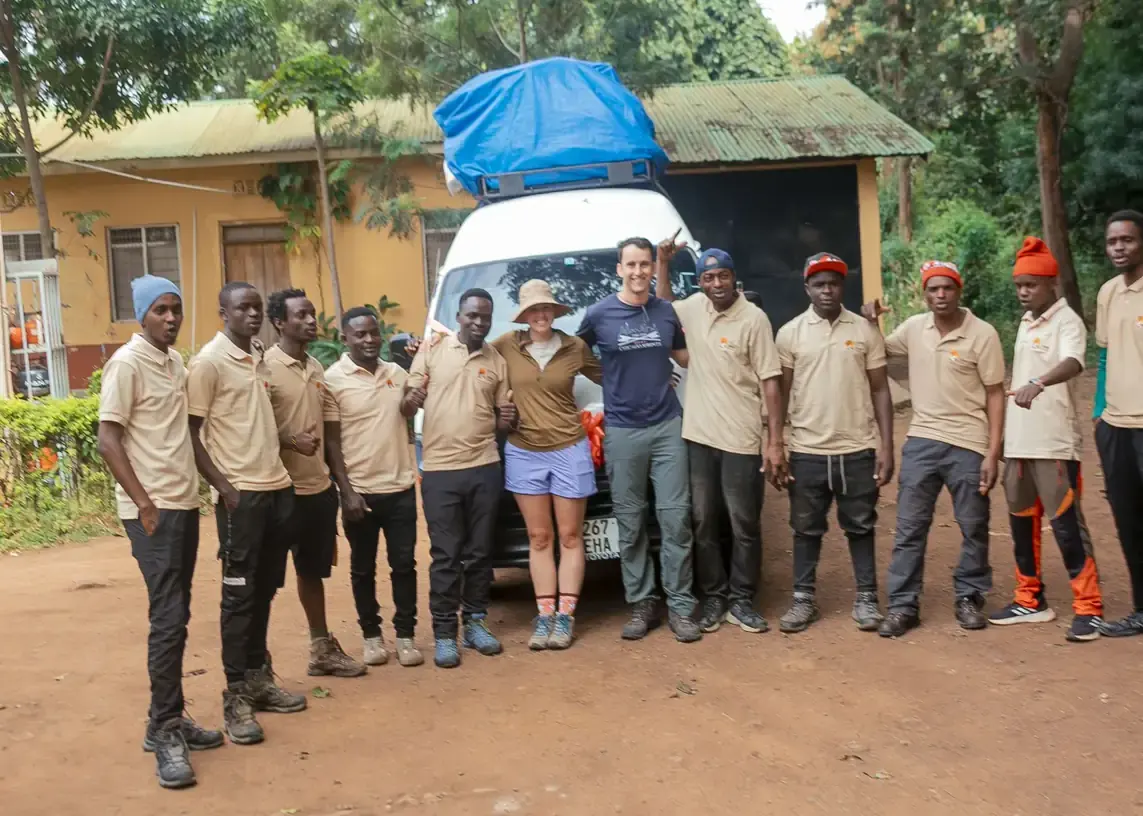A honeymoon couple with their Jaynevy Tours guides and porters in uniform beside the climb vehicle before leaving for the mountain