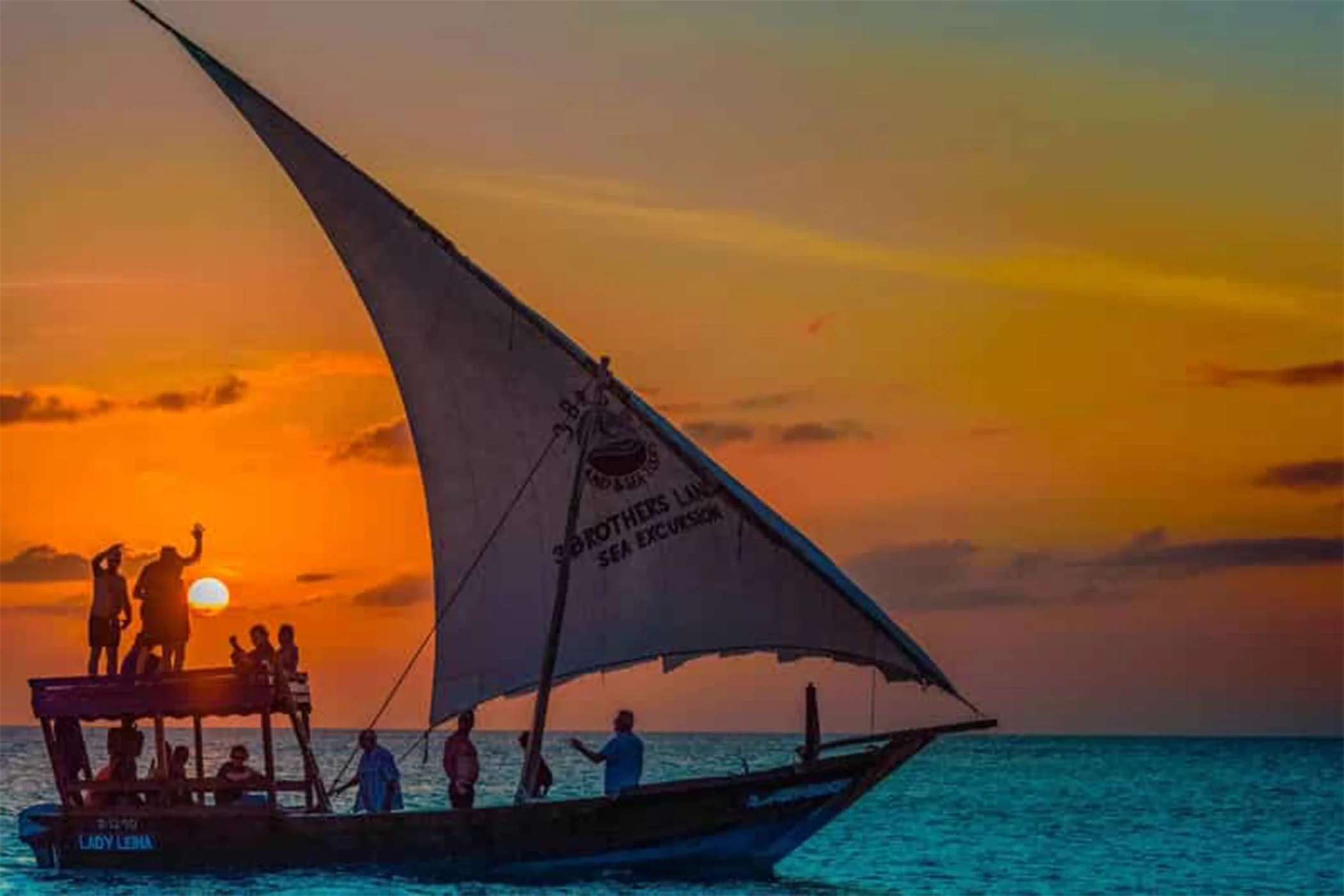A traditional dhow under sail at sunset off the coast of Zanzibar